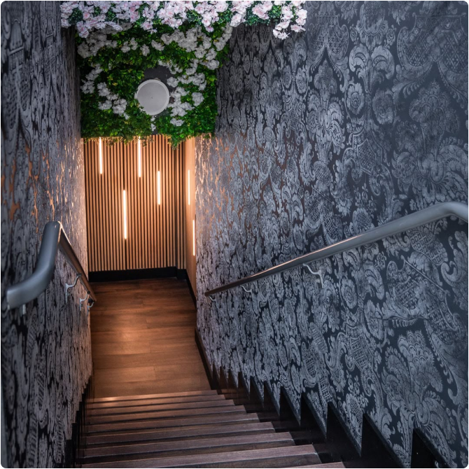 The intimate Tokyo Sushi Speakeasy dining room in warm, moody light.