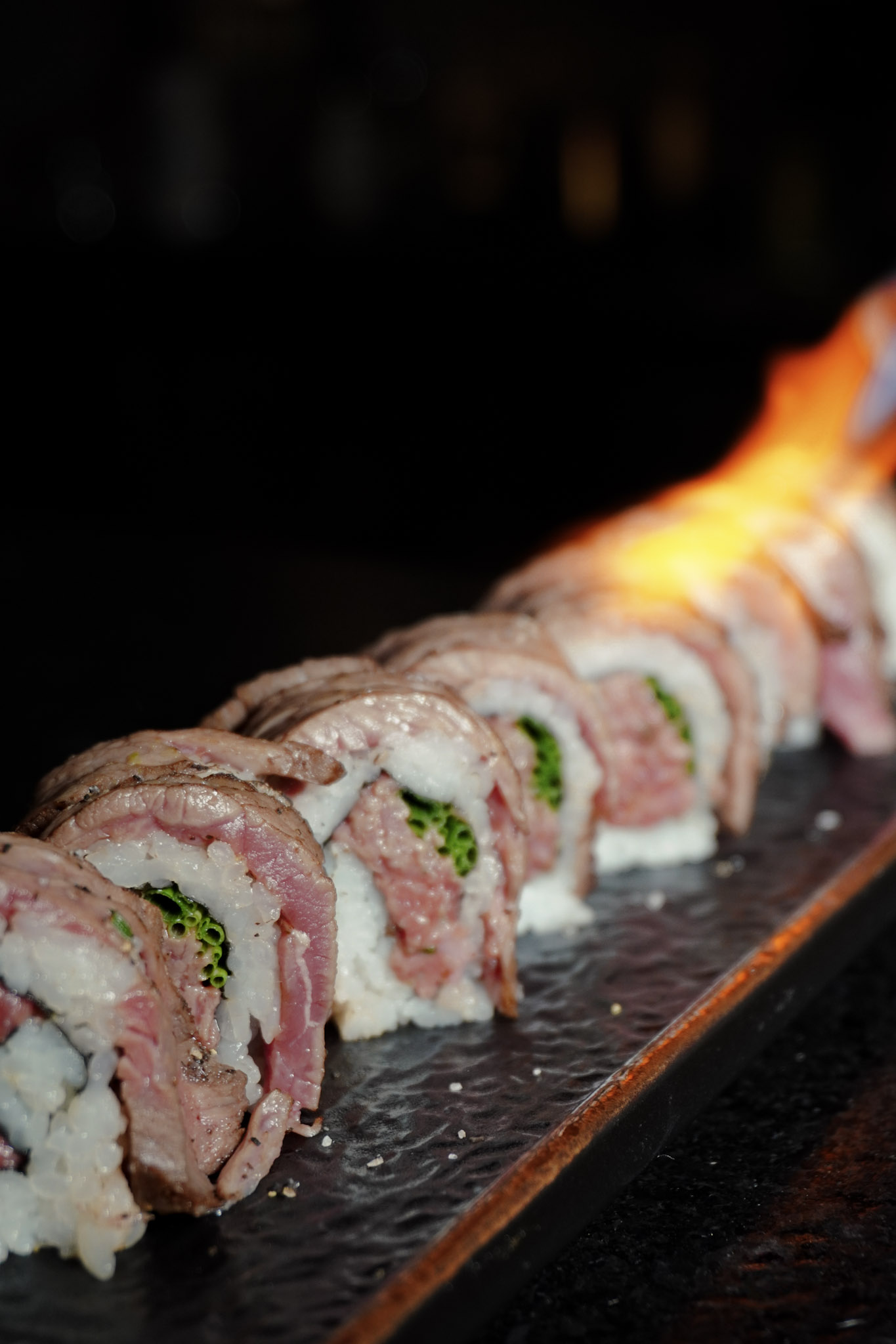 A wagyu sushi roll finished tableside with a burst of flame.