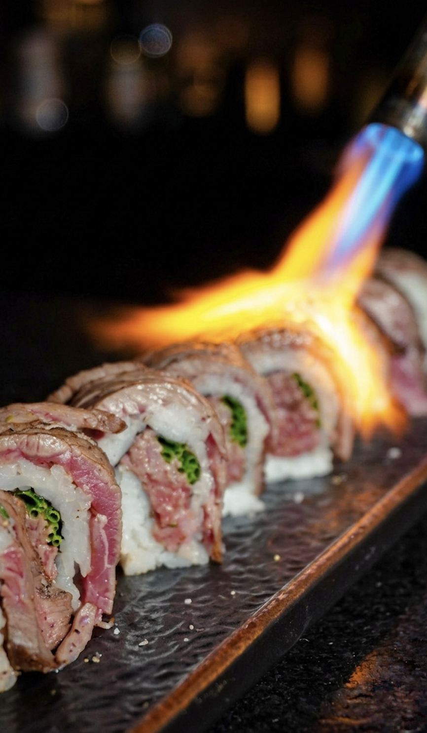 A torched wagyu sushi roll finished with flame at Tokyo Club Sushi Speakeasy.